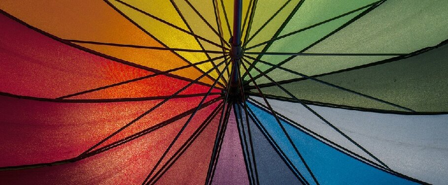 The shaded colors of the underside of a multi-color umbrella